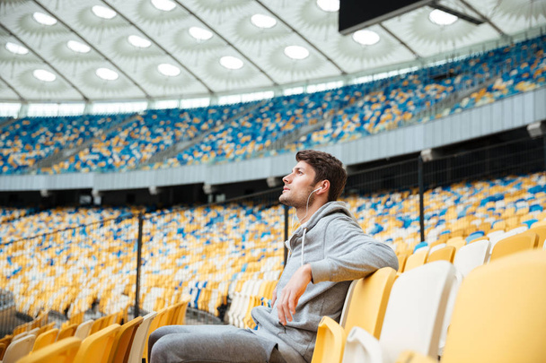 Handsome young sports man at the stadium outdoors - Fotoğraf, Görsel