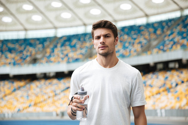 Young male athlete holding bottle of water - 写真・画像