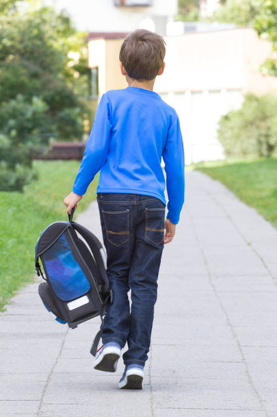 Мальчик с рюкзаком ходит в школу. Вид сзади
. - Фото, изображение