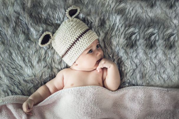 neugeborenes Mädchen posierte in einer Schüssel auf dem Rücken, auf einer Decke aus Fell - Foto, Bild