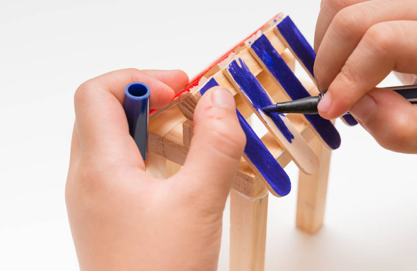 kid doing color painting for a wooden house model - Photo, Image