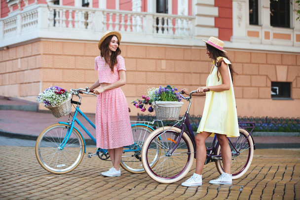 Young ladies standing outdoors with bicycles - Fotografie, Obrázek