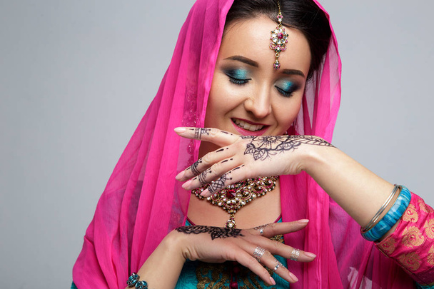 Retrato de una hermosa chica india sonriente. Modelo de mujer india joven con conjunto de joyas tradicionales. Traje indio saree
 - Foto, Imagen