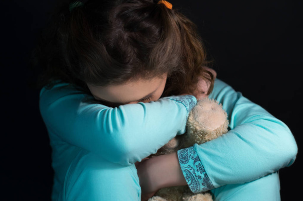 Teenage depression, crying girl holding a teddy bear - Фото, зображення