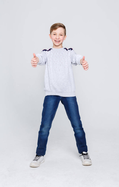 Портрет веселого мальчика, показывающего большой палец вверх.
 - Фото, изображение