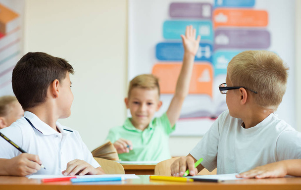 Portrait of schoolboy raises his hand at the lesson - Foto, Bild