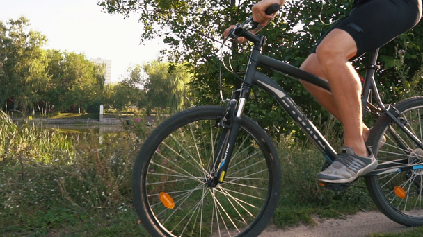 Male cyclist rides on the road - Materiał filmowy, wideo