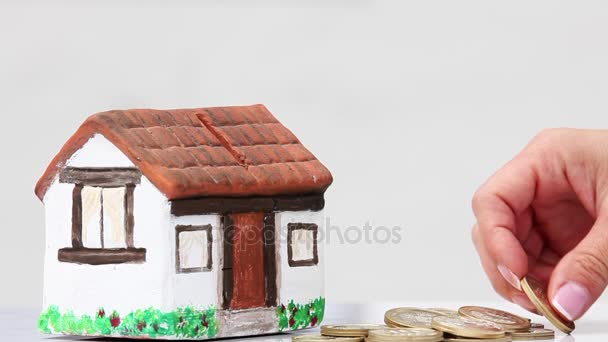 Mujer ahorrando dinero en una caja de dinero de la casa
 - Metraje, vídeo