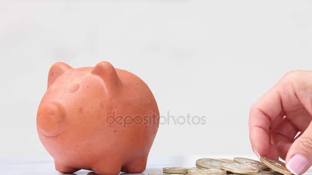 Mulher economizando dinheiro em um tradicional banco de argila porquinho
 - Filmagem, Vídeo