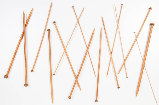 Variedad de agujas de punto de madera en diferentes tamaños sobre fondo blanco
 - Foto, Imagen
