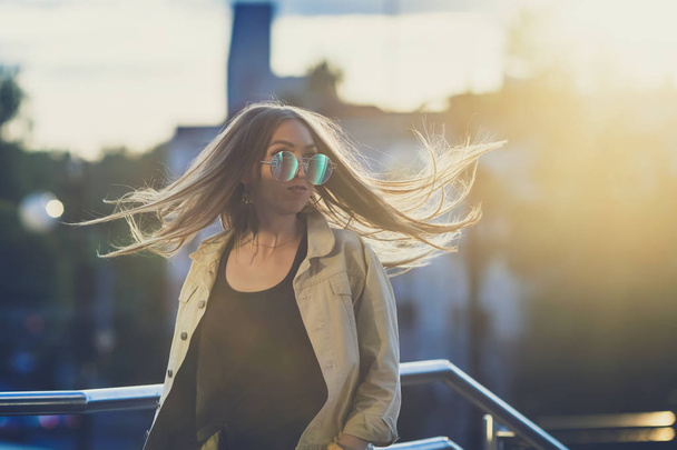 Young woman in sunglasses have fun with outdoor, sunset in the background. - Fotó, kép