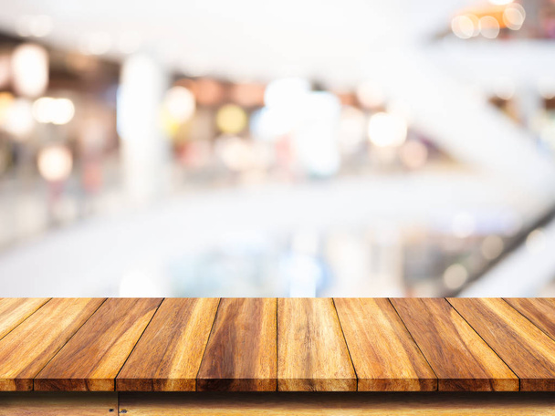 Lege top van houten tafel met winkelcentrum achtergrond wazig. - Foto, afbeelding