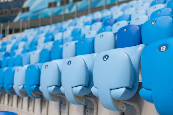 Ряды синих мест на футбольном стадионе. Удобное сидение для всех
 - Фото, изображение