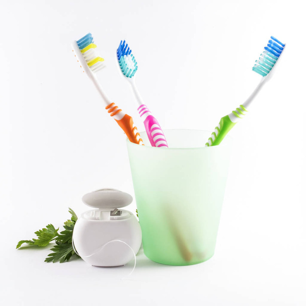 Cepillos de dientes y hilo dental sobre fondo blanco
 - Foto, Imagen