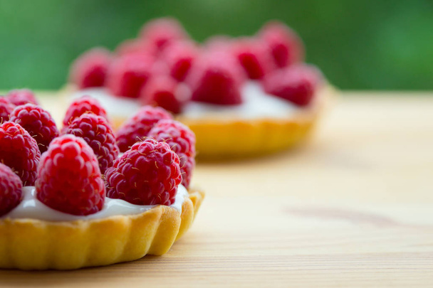 raspberry tarts on a wooden table - Valokuva, kuva