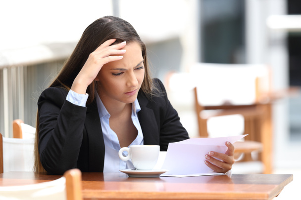 Worried executive reading letter in a coffee shop - Photo, image