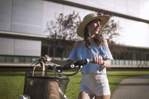 Portrait of beautiful woman enjoying time on bicycle - Photo, Image