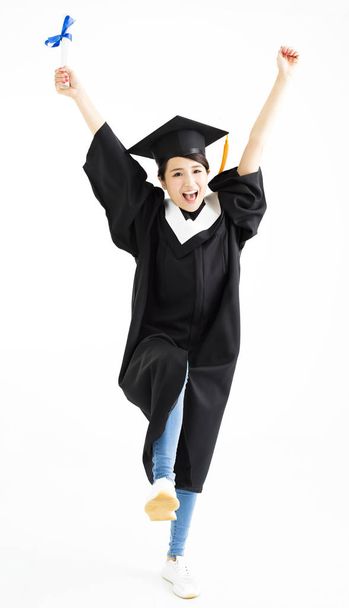 Gelukkig afstuderen student dansen en diploma tonen - Foto, afbeelding