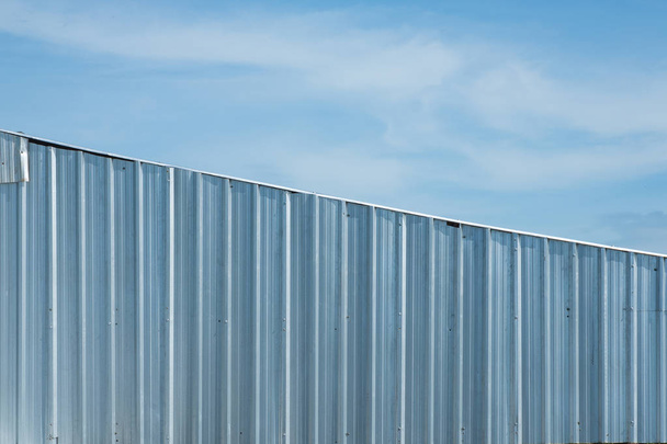 silver metal sheet wall, aluminium corrugate wall with blue sky - Valokuva, kuva