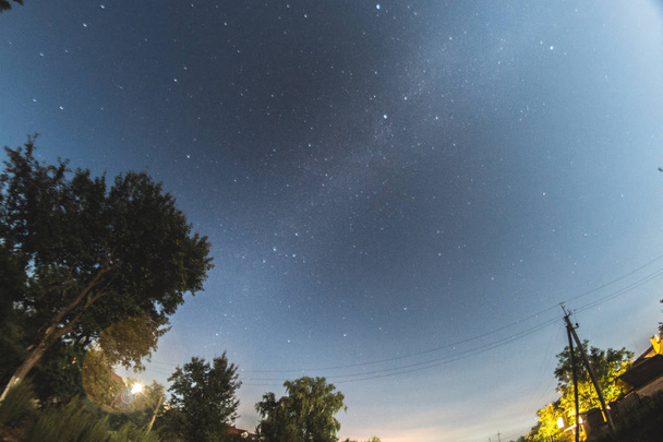 Звездное небо в летний вечер над деревней
. - Фото, изображение