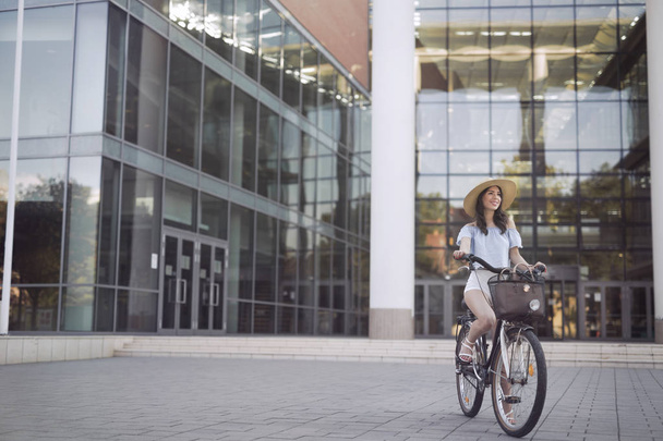 Portrait of beautiful young woman enjoying time on bicycle - Zdjęcie, obraz