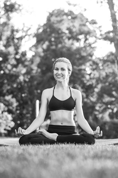 Young woman practicing yoga outdoors at the park - Fotoğraf, Görsel