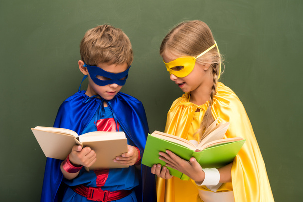 pupils in superhero costumes with books - Photo, Image