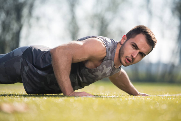 Sports Man Doing Pushups in the Park - Photo, image