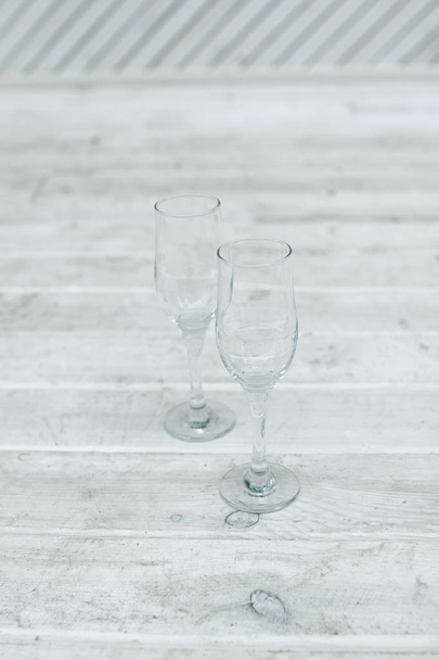 Empty glasses stand on a white wooden background - Fotoğraf, Görsel