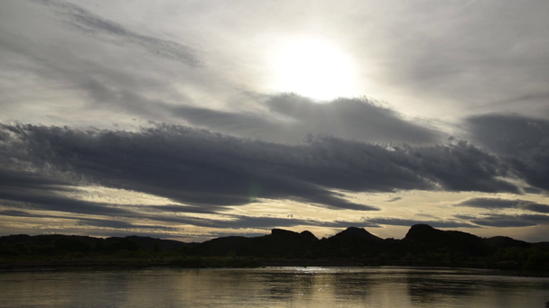 mraky táhnou nad klidné waterscape s vzdálené hory - Záběry, video
