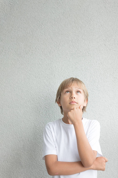 Portrait of thoughtful boy with crossed arms looking up - Photo, Image