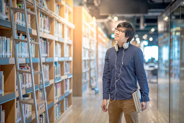 Młoda Azji człowiek student Uniwersytetu w bibliotece - Zdjęcie, obraz