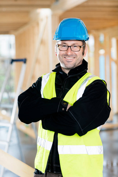 Mature Carpenter Standing Arms Crossed At Construction Site - Photo, image
