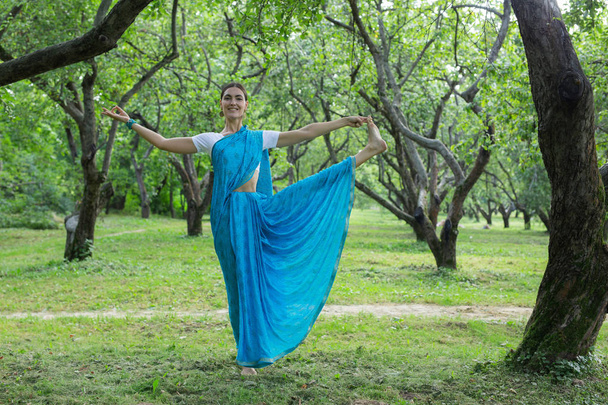 Mooie jonge Indiase vrouw gekleed in een sari bidden en medit - Foto, afbeelding