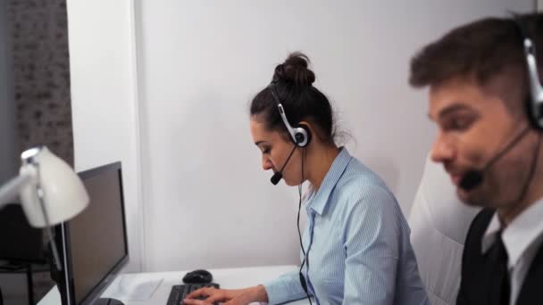 Kundenservice-Team nimmt Anrufe in belebtem Call Center entgegen. - Filmmaterial, Video
