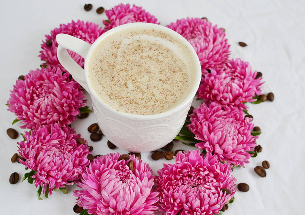 カップ コーヒー テーブル ホワイトの背景のピンクの花  - 写真・画像