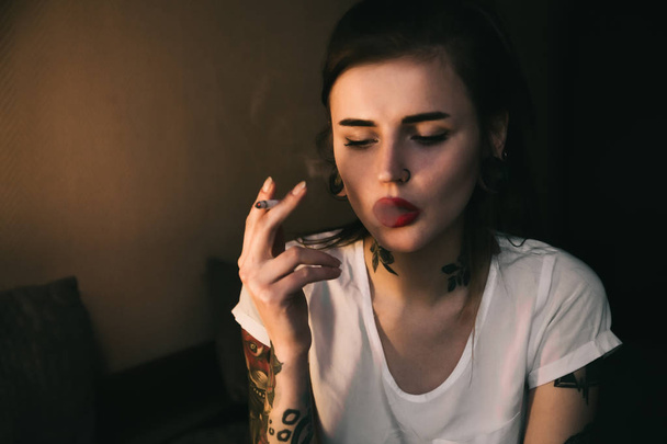 Jeune femme tatouée fumant
 - Photo, image