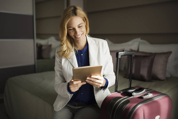 Portrait of attractive businesswoman using tablet on bed - Foto, Imagen