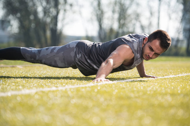 Attractive Man Doing Pushups Outside - Photo, image