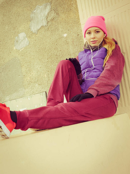 Woman wearing warm sportswear relaxing after exercising - Foto, afbeelding