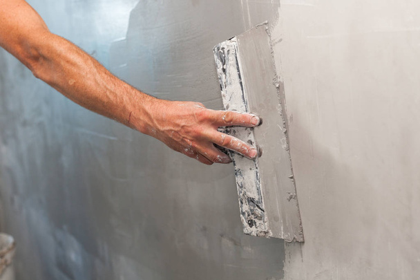 Man hand with trowel plastering a wall. - Photo, Image