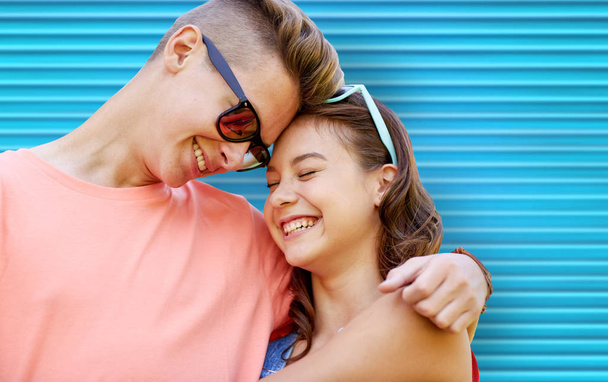happy teenage couple with sunglasses hugging - Foto, afbeelding