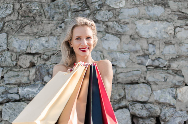 Mujer rubia con bolsas de compras
 - Foto, imagen