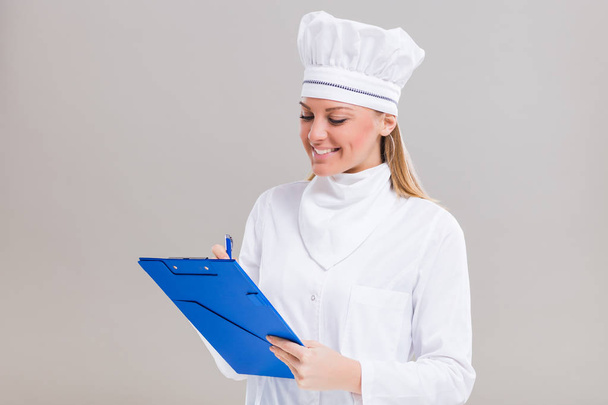 Female chef  holding cookbook  - Фото, зображення