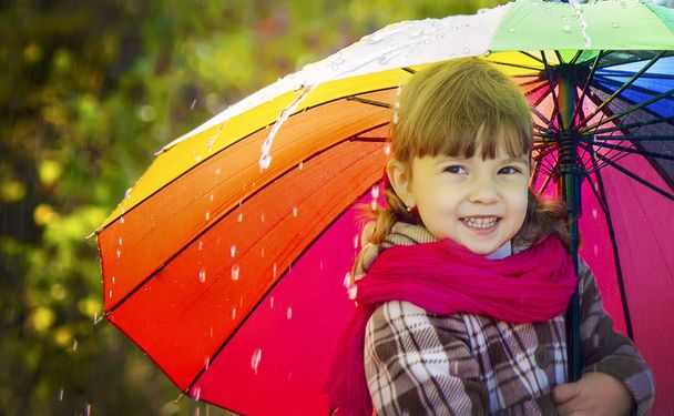Дитина під дощем. З парасолькою. Вибірковий фокус
.  - Фото, зображення