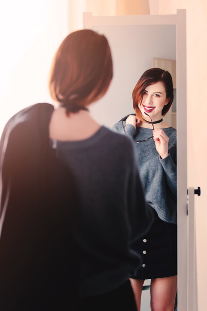 Woman standing in front of mirror  - 写真・画像