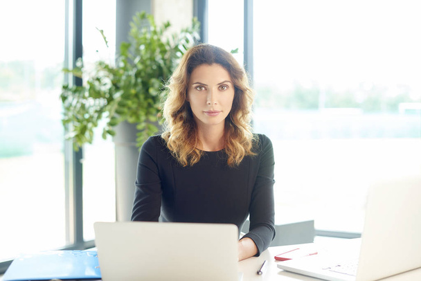  businesswoman sitting at desk - Photo, Image