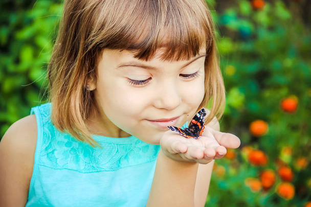 Child with a butterfly. Selective focus. - Foto, Bild