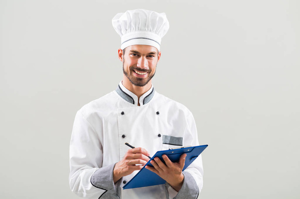 Chef  holding cookbook and writing  - Foto, imagen