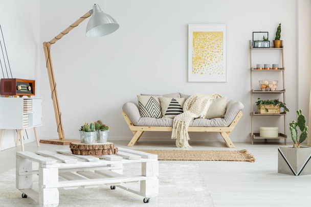 Wooden shelf next to designed sofa - Фото, изображение